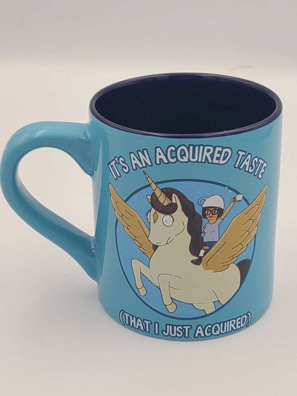 Bob's Burgers It’s An Acquired Taste Tina Unicorn 14 oz Blue Ceramic Coffee Mug